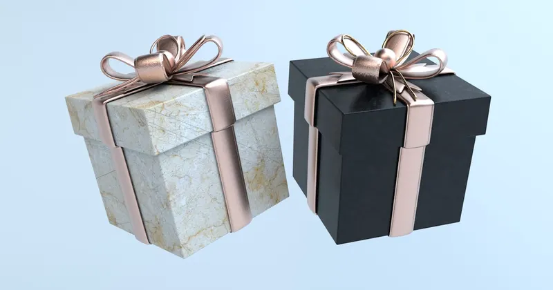 two black and white boxes with gold bows